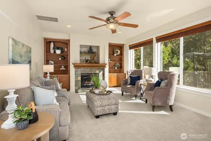 The light-filled family room features a gas fireplace, custom built-ins, and peaceful views of the private backyard.