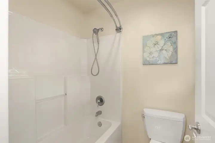 The shower/tub and toilet are tucked away from the vanity — making it easy for two people to share the space at once.