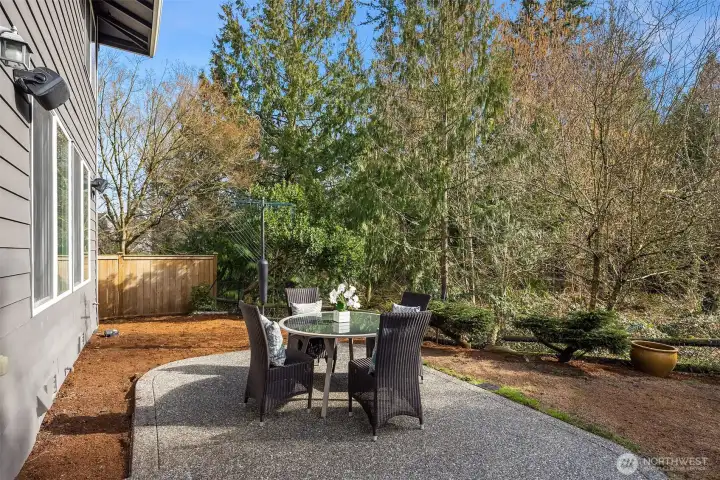 The patio backs to a lush, private greenbelt — a serene outdoor retreat freshly landscaped with new mulch and grass seed