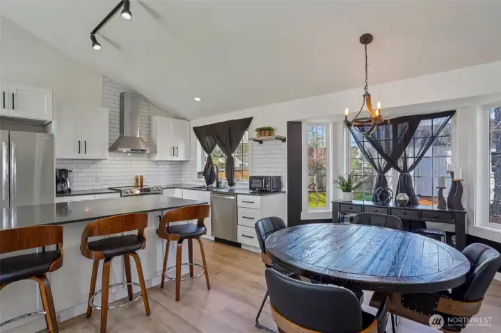 Updated kitchen features quartz countertops, custom cabinetry, stainless steel appliances, tile backsplash, and an oversized island.