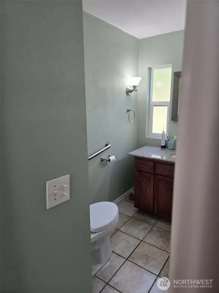 Grab bar on wall. Granite counter top.