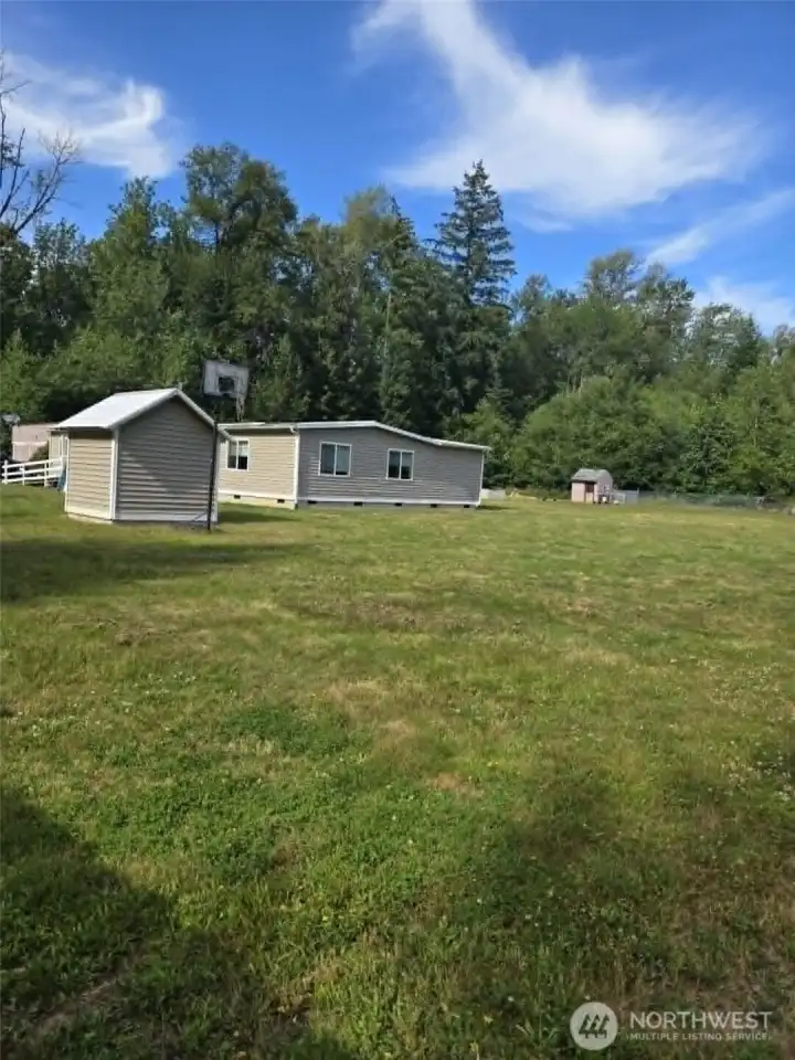 End view of home with well house on left and chicken house on right