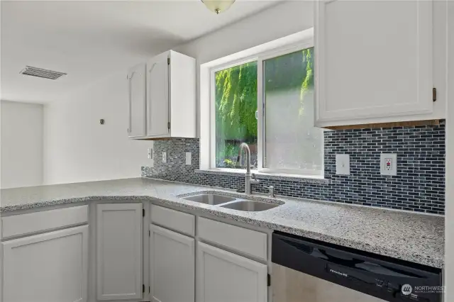 Beautiful view of the trees and side yard out the kitchen window. Notice the stylish backsplash!