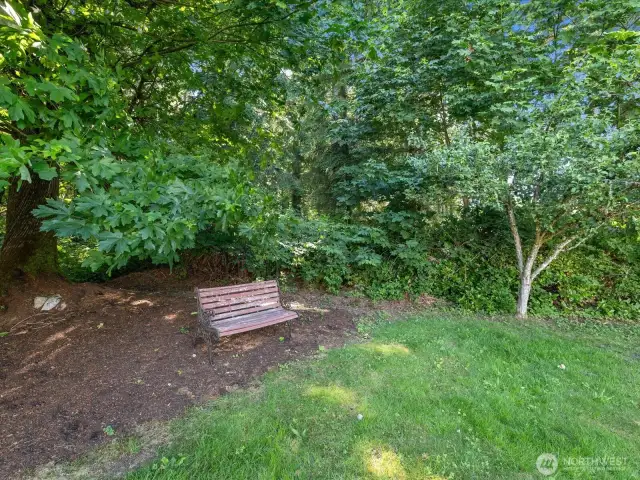 Beautiful sprawling yards create outstanding outdoor spaces, with    mature trees, many blooming flowers, & large wooded area.