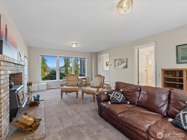 Large Family Room off the Kitchen with Woodstove, wall of view windows & 2 doors - 1 out to back Deck & 1 out to Front/Side entrance.