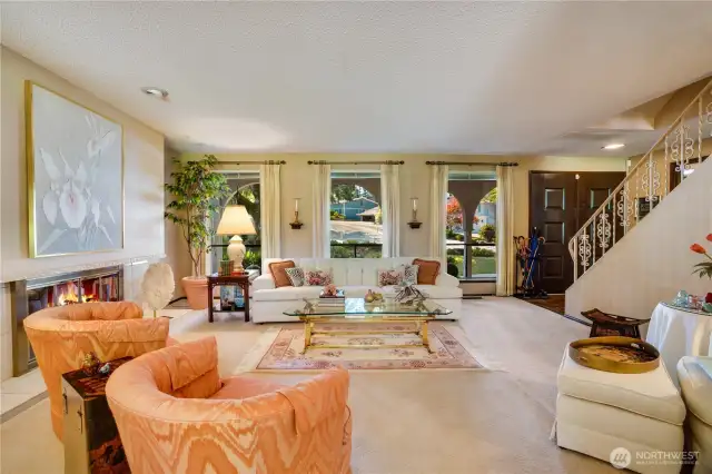 Living room is framed by floor-to-ceiling picture windows, flooding the home with radiant natural light.
