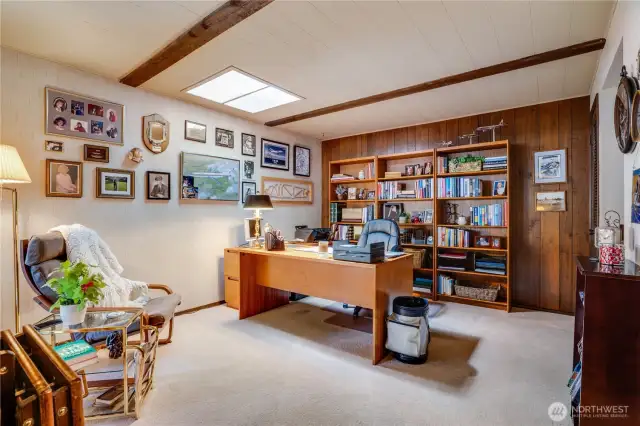 Create a cozy main floor den or bedroom, a chic beverage station with open shelving, and seamless access to a half bathroom through a sleek pocket door.