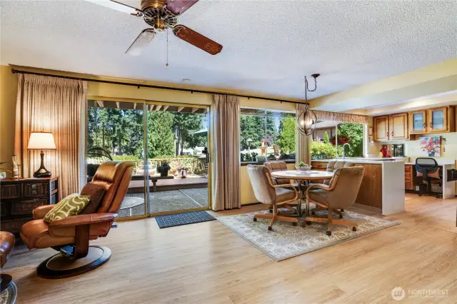 This home strikes a perfect balance of indoor-outdoor living with floor-to-ceiling sliding glass doors that seamlessly connect a spacious, light-filled interior to a sprawling deck overlooking lush greenery.