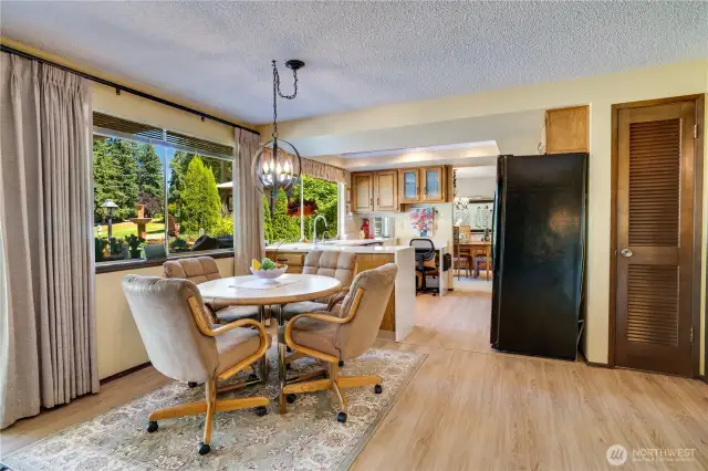 Enjoy casual dining with a wall of windows overlooking a spacious patio and deck, creating the perfect spot for savoring a morning cup of coffee while soaking in views of the golf course.