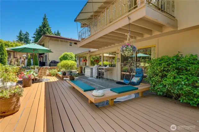 The outdoor space features built-in bench seating with plush cushions and a sleek sit-up bar that seamlessly opens into the kitchen, creating a perfect flow for entertaining with easy access to refreshments.