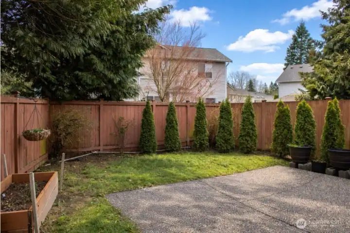 Cyprus trees that will grow to create even more privacy, mature blueberry bushes and built in garden bed for veggies or flowers galore!