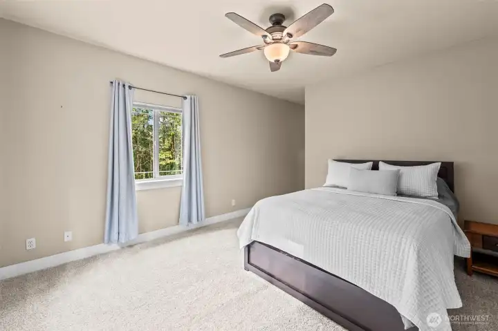 Primary bedroom on main level with walk-in closet and ensuite bath.