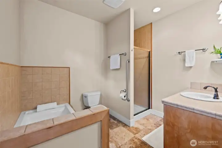 Primary ensuite bathroom with jetted tub and tiled shower.