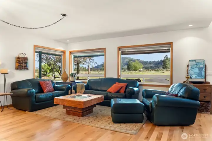 Large great room for gathering enjoys surrounding views from each window. Gleaming maple hardwood floors  throughout the main floor of the home. Massive Stone and rock fireplace glow deeply warms all in Winter. Solid wood doors, window trim shine. Quality finish work.