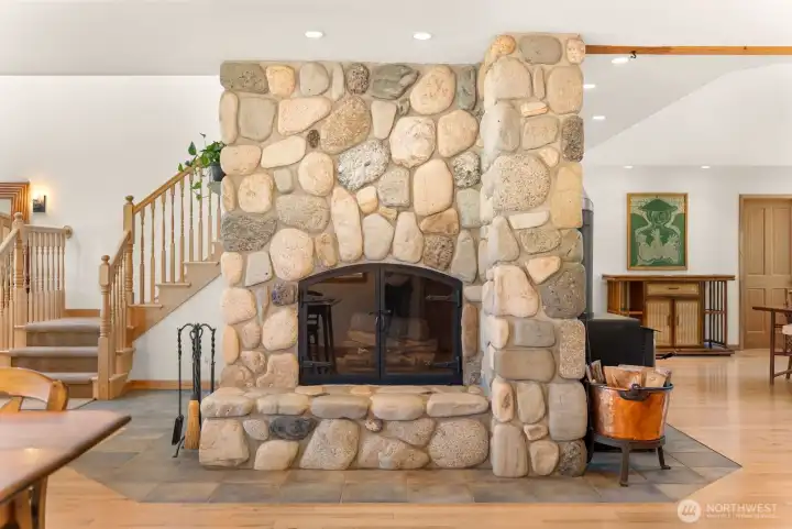 Custom stone and rock fireplace is a solid masterpiece in the center of main floor living area. Ceramic tile beauty surround base. Seen from Great room, Kitchen, Dining room and entrance foyer, offering a different side of the grand stone and rock work of art.