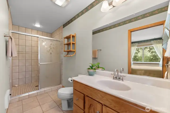 Ensuite Bath to Main level guest bedroom. Tile floor. Large shower.