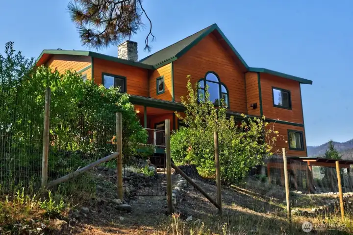 Back of home has trail to your own riverfront setting to splash and dip your toes in the refreshing clear water. Backyard partially fenced to allow flowering trees and bushes to flourish. Also garden area and garden shed.  Custom garden gates.