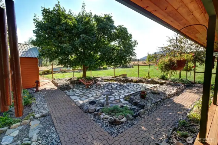 Lovely shade tree over mosaic patio is like no other. Landscape has a variety of hardscape which is low maintenance.