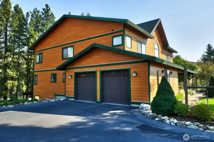 Double attached Garage is on West side of the home. Asphalt driveway is an additional parking area here.
