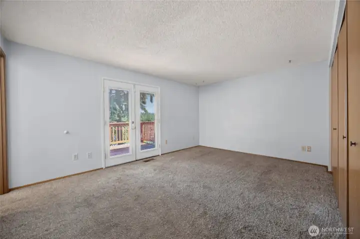 Primary bedroom with french doors leading out to balcony/deck