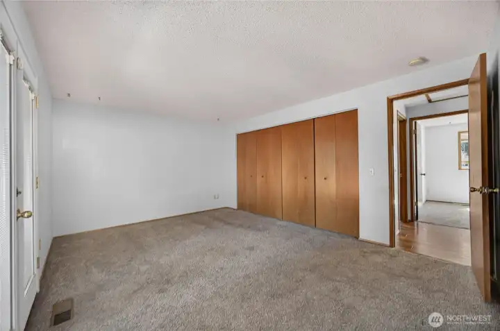 Primary bedroom with french doors leading out to deck and attached bathroom
