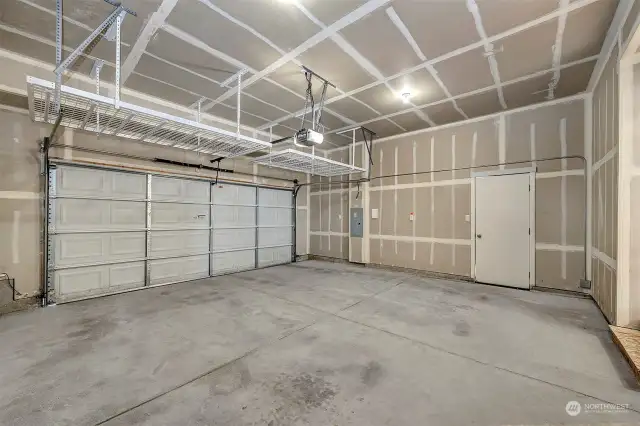 Garage with storage shelves and access to the side yard