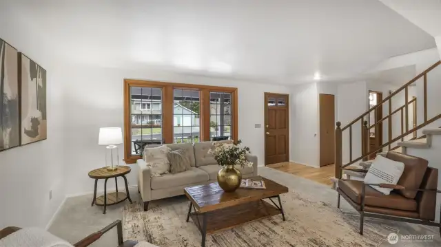 Light-filled living room with a wall of windows, bringing in abundant natural light and serene outdoor views.