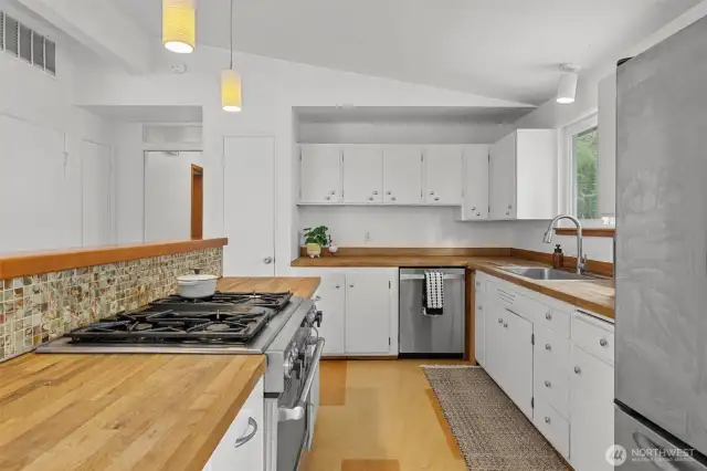Butcher block countertops in kitchen with original flooring