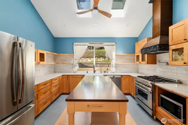 Kitchen island with plenty of outlets! High-end finishes, a pot-filler, and a carved Italian hood above commercial six burner gas range (with hybrid oven!) round out this exceptional kitchen.