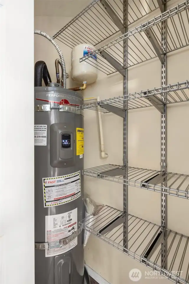 Brand new Rheem 50 gallon water heater located in closet at entry with plenty of shelving for storage.
