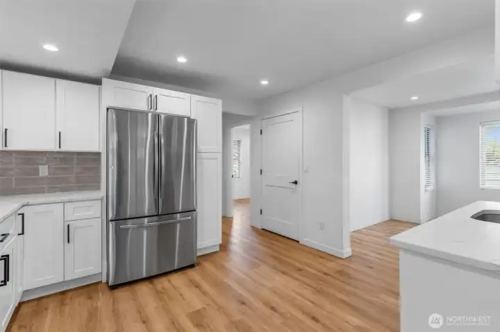 White cabinetry and full-height tile backsplash add a modern twist to this gourmet kitchen.