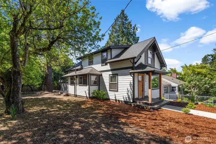 Front and side view of the exterior with mature growth.