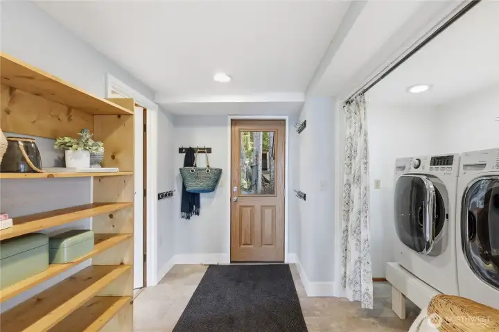 Side door with laundry in hallway.  Door on the left leads down to the basement