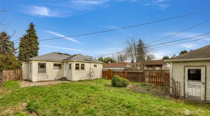 Detached garage has door within fenced back yard