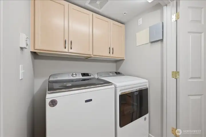 Full washer and dryer in unit with storage cabinets