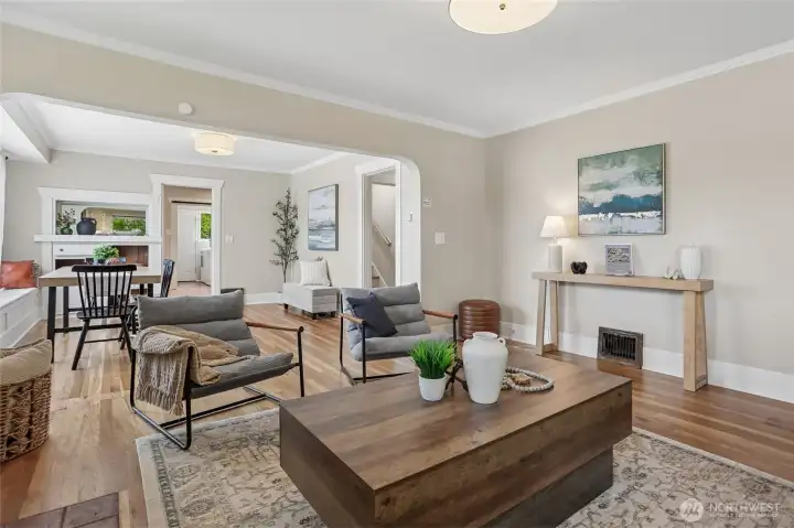 A seamless flow connects the dining and living spaces, showcasing gorgeous refinished original hardwood floors that carry warmth and character throughout the main level. A seamless flow connects the dining and living spaces, showcasing gorgeous refinished original hardwood floors that carry warmth and character throughout the main level.