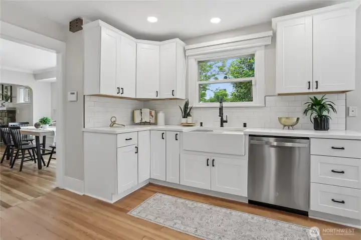 The updated and redesigned kitchen blends modern design with timeless Craftsman appeal, featuring crisp cabinetry, sleek countertops, and all new stainless steel appliances. A statement farmhouse sink and stylish finishes create both beauty and function, while the open layout flows effortlessly across the main level’s original hardwood floors. The updated and redesigned kitchen blends modern design with timeless Craftsman appeal, featuring crisp cabinetry, sleek countertops, and all new stainless steel appliances. A statement farmhouse sink and stylish finishes create both beauty and function, while the open layout flows effortlessly across the main level’s original hardwood floors.