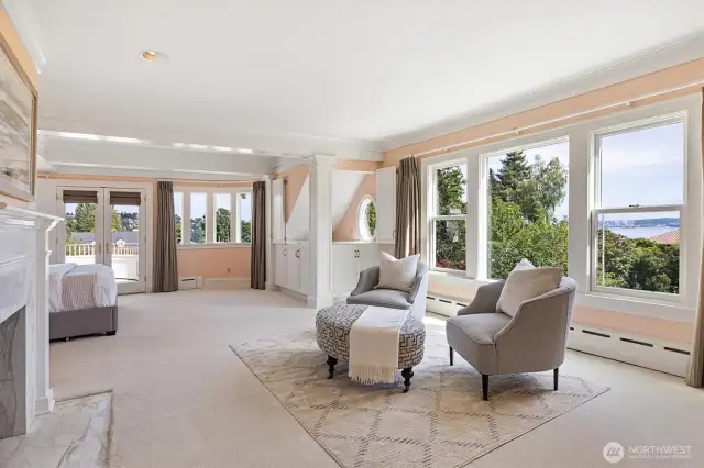 Primary suite complete with dual bathrooms and dual walk-in closets. Views of Mt. Rainier, Seattle skyline and Puget Sound. French doors lead to private view balcony with Porcelanosa tile.