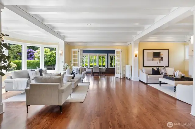 Expansive living room, fireplace setting, newly refinished hardwood floors, and coffered ceilings restored to perfection.