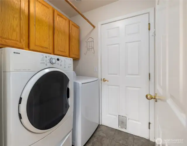 Laundry room with extra storage and the door leads you to the two car garage.