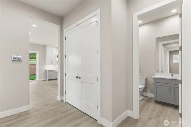 Main-level bedroom with neutral finishes, wide-plank flooring, and convenient access to an adjacent full bath. Ideal for guests, extended stays, or a private home office setup.