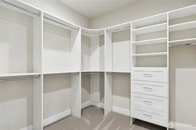 Spacious walk-in closet with custom built-in shelving, drawers, and double hanging rods—designed for maximum storage, organization, and convenience right off the primary suite.