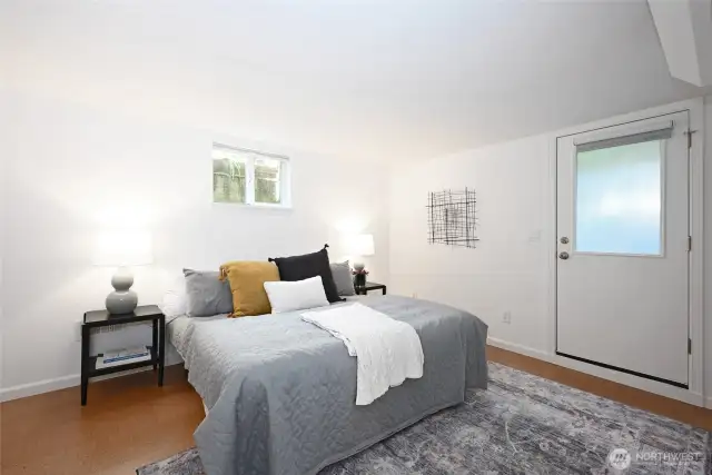 Comfortable basement bedroom with an exterior door.