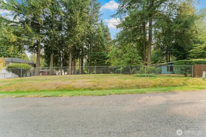 Street view. This lot as been maintained for many years. Access is through the driveway gate on the home on the right which is also part of the estate sale. Close to the gated Shadow Lake Community Beach - optional membership available.