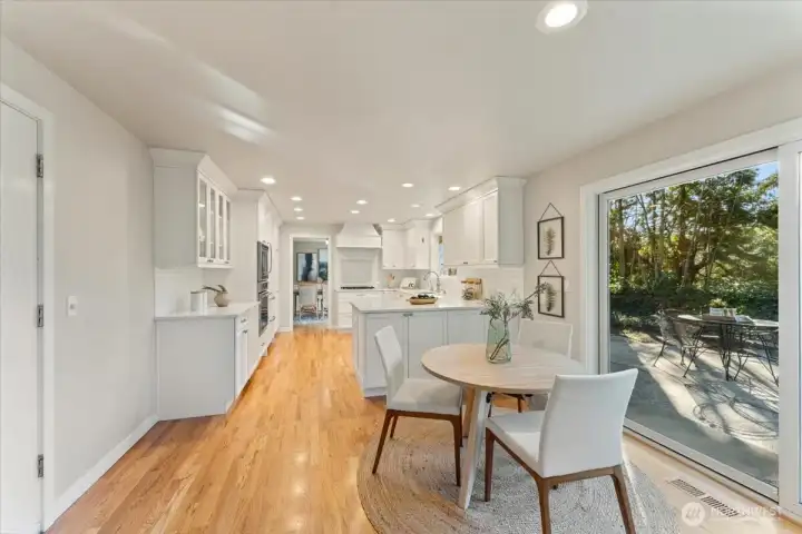 Updated kitchen features custom Bellmont cabinetry and generous storage, with a nearby garage door providing seamless grocery access.