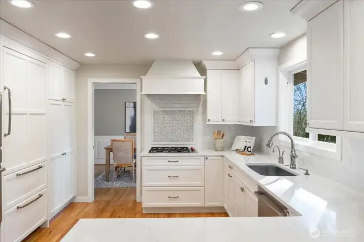 A paneled Sub-Zero refrigerator delivers a seamless, integrated aesthetic, while the ideal cooking triangle and abundant prep space offer exceptional functionality for any cook.