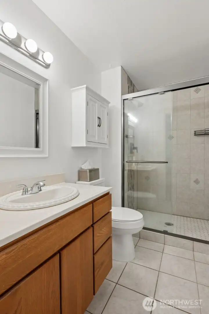 Primary Bath with tile flooring and updated walk-in shower.