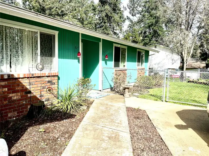 Inviting entry with fresh exterior paint, and flower beds.