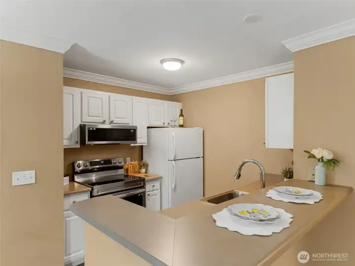 The kitchen with newer stainless steel range & microwave also features white cabinets.
