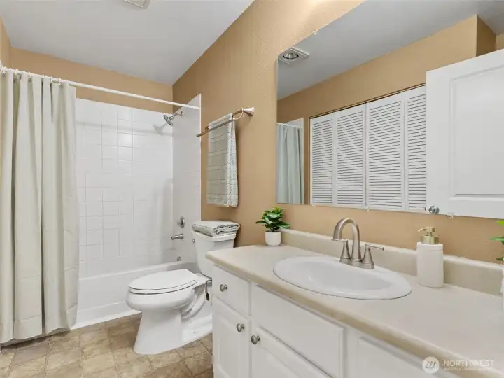 The bathroom has plenty of cabinets and counter space.